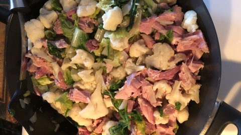 chunks of ham, cauliflower, spinach and greens for ham casserole in frying pan