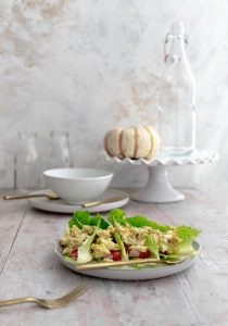 lettuce leaves with chicken salad displayed in front of white place setting